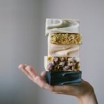 a person holding a pile of homemade soap