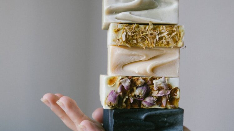 a person holding a pile of homemade soap